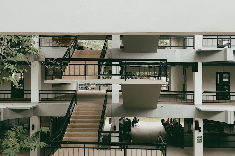 The modern, sunlit atrium of a university's business school building.